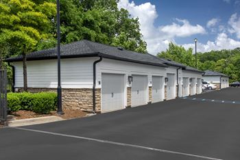 A long row of garages with trees in the background.
